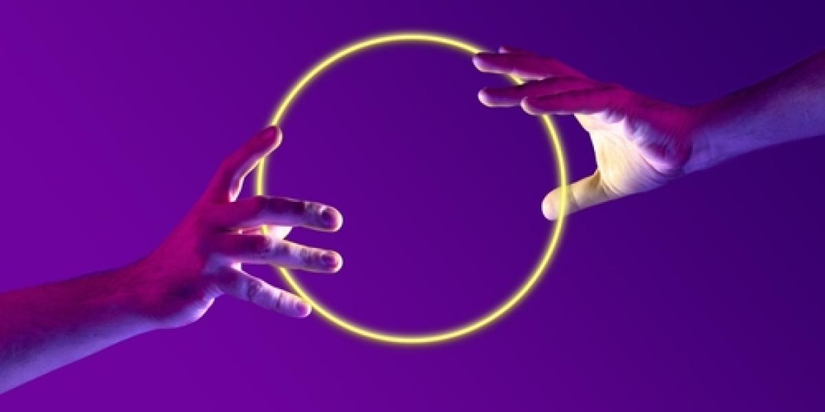 ידיים אנושיות מחזיקות כדור עגול ניאוני זוהר על רקע מופשט בצבע סגול מינימליסטי